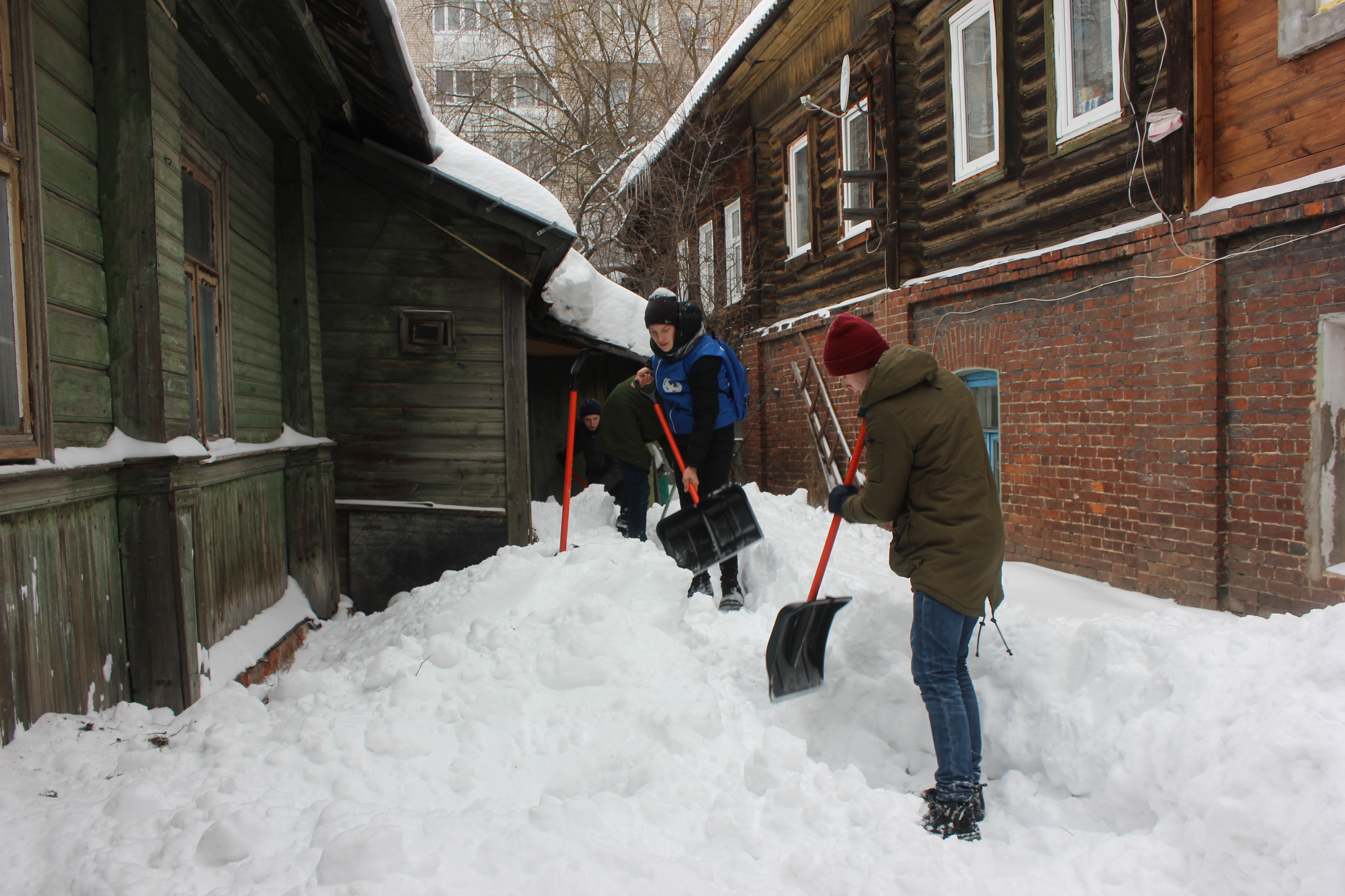 Помощь снежку. Волонтеры помогают пожилым людям очистить двор от снега. Пенсионер убирает снег у частного дома. Волонтеры помогают бабушки зимой. Фото волонтеры фото старикам зимой.